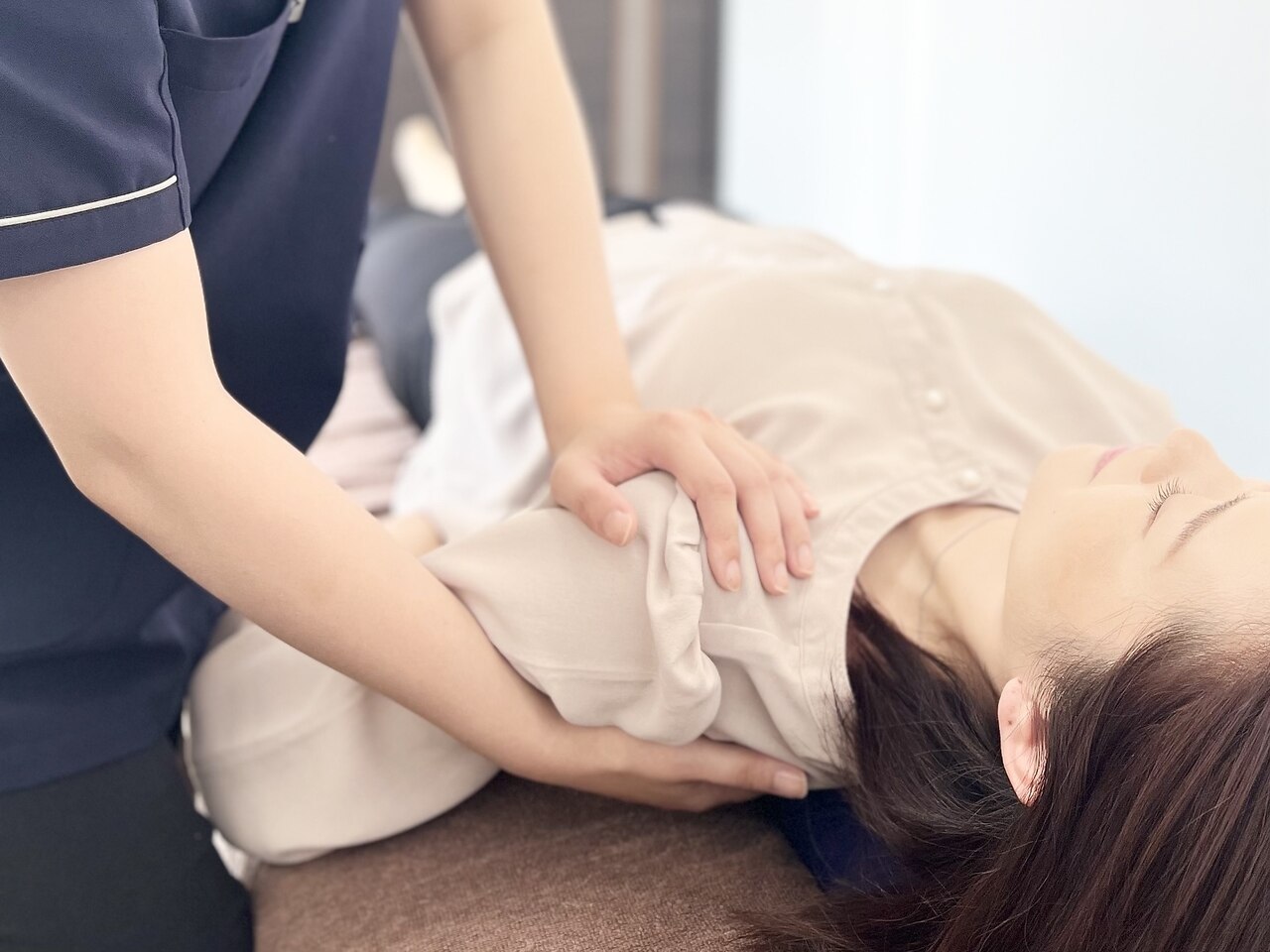 鈴鹿の整体『まはろ整体 鈴鹿岡田店』で腰痛改善のために骨盤と腰背部をケアする様子